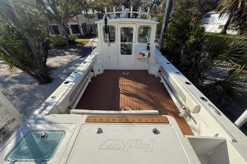 Slide: The Image of 2020 Parker 2320 SL Sport Cabin boat deck with seating and coiled hose. - 18