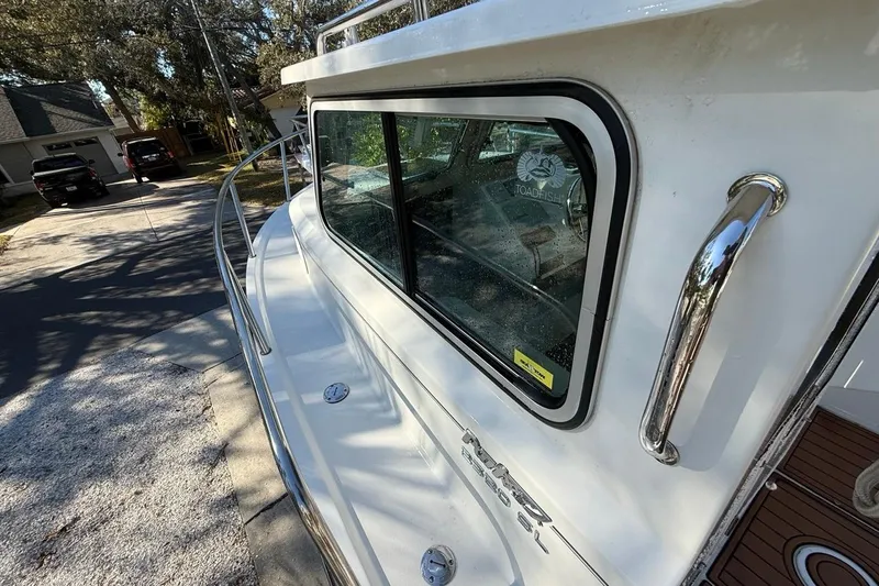 Slide: The Image of 2020 Parker 2320 SL Sport Cabin boat parked in a residential driveway. - 24
