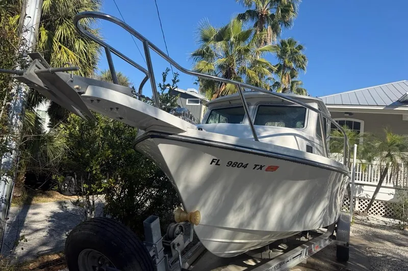 Slide: The Image of 2020 Parker 2320 SL Sport Cabin boat on trailer, parked in a residential driveway. - 3