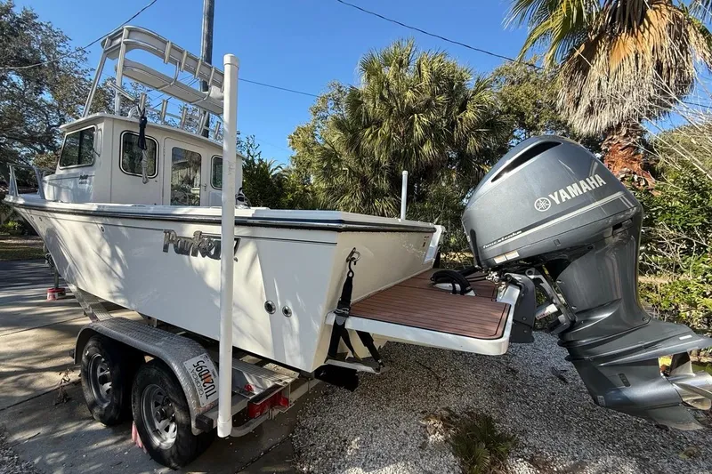 Slide: The Image of 2020 Parker 2320 SL Sport Cabin boat on trailer, surrounded by palm trees. - 47