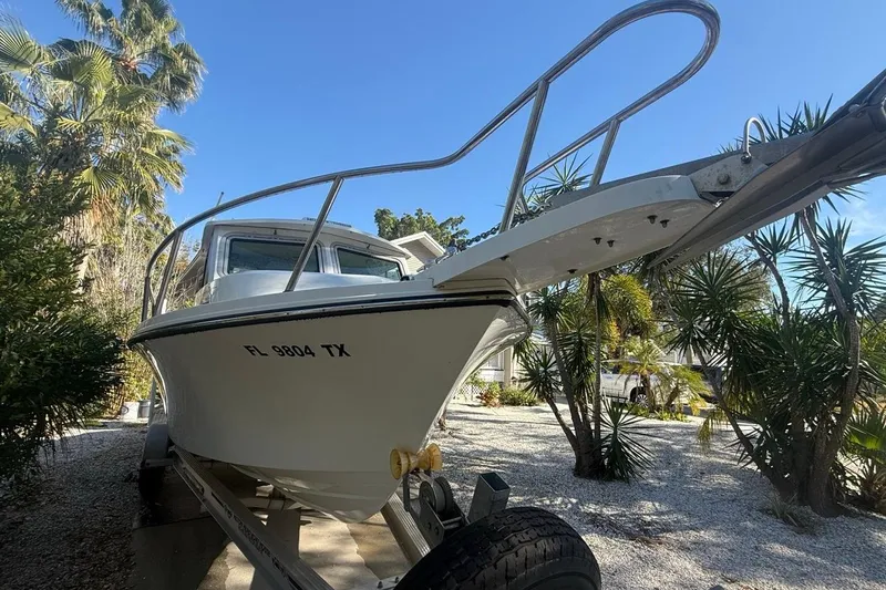 Slide: The Image of 2020 Parker 2320 SL Sport Cabin boat on trailer, sunny day, palm trees in background. - 5