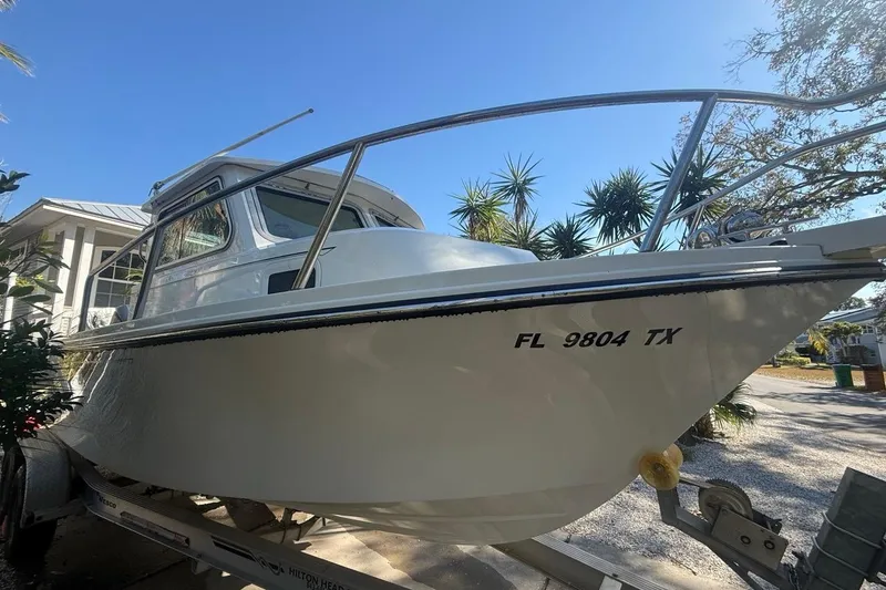 Slide: The Image of 2020 Parker 2320 SL Sport Cabin boat with Yamaha outboard motor in sunny outdoor setting. - 6