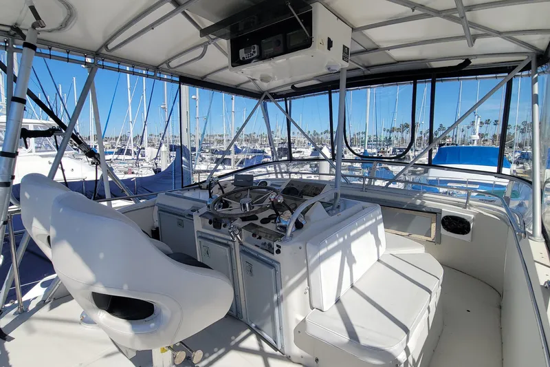 Slide: The Image of 1984 Uniflite 38 Convertible yacht cockpit with steering wheel and marina view. - 12
