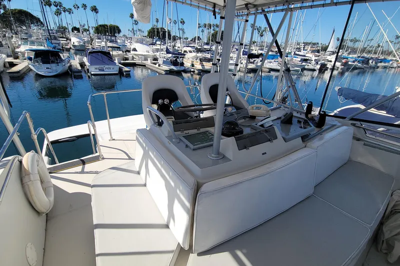 Slide: The Image of 1984 Uniflite 38 Convertible yacht helm with marina view, featuring modern controls and seating. - 16