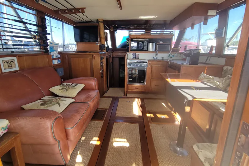 Slide: The Image of Interior of 1984 Uniflite 38 Convertible yacht with cozy seating and kitchen area. - 17