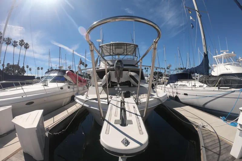 Slide: The Image of 1984 Uniflite 38 Convertible yacht docked at marina under clear blue sky. - 2