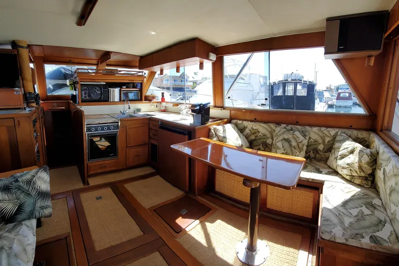 Slide: The Image of 1984 Uniflite 38 Convertible yacht interior with kitchen, dining area, and large windows. - 20
