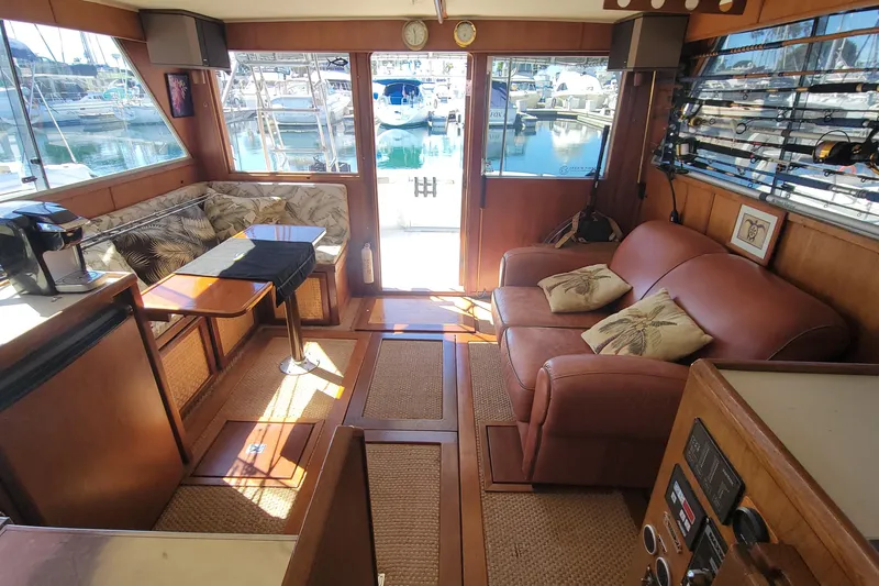 Slide: The Image of Interior of 1984 Uniflite 38 Convertible yacht with cozy seating and marina view. - 22