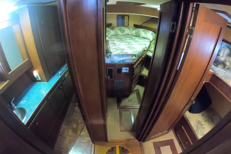 Slide: The Image of 1984 Uniflite 38 Convertible interior with wood finish, cozy sleeping area, and compact kitchenette. - 23