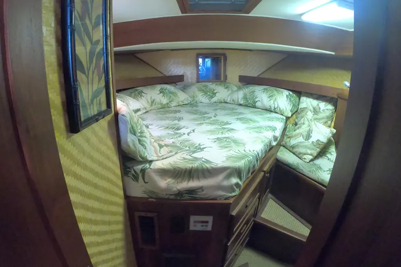 Slide: The Image of 1984 Uniflite 38 Convertible cabin with tropical-themed bedding and wooden interior. - 24