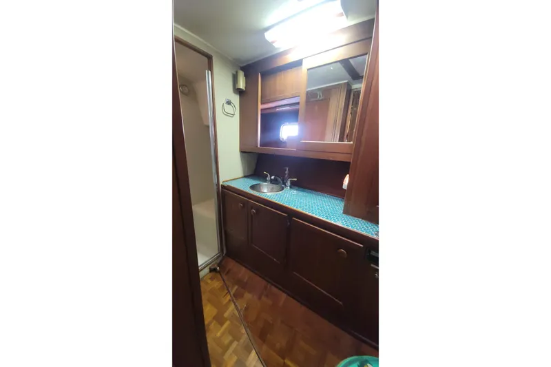 Slide: The Image of 1984 Uniflite 38 Convertible yacht bathroom with wood cabinetry and blue countertop. - 26