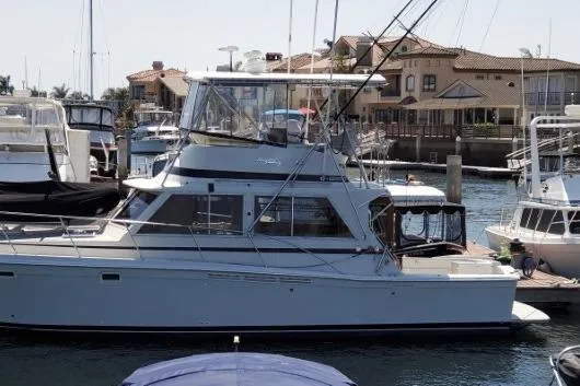 Slide: The Image of 1984 Uniflite 38 Convertible yacht docked in a marina, surrounded by other boats. - 3