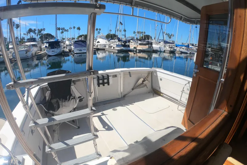 Slide: The Image of 1984 Uniflite 38 Convertible yacht docked in a marina with clear blue skies. - 7