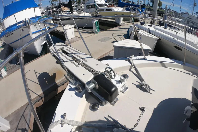 Slide: The Image of 1984 Uniflite 38 Convertible yacht docked at marina, showcasing bow and anchor equipment. - 9