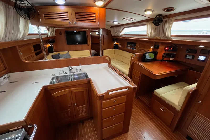 Slide: The Image of Luxurious 2011 Outbound 46 yacht interior with wood finish, kitchen, seating, and navigation area. - 36