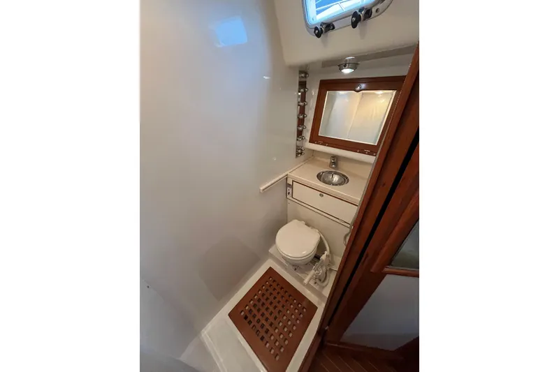 Slide: The Image of 2011 Outbound 46 yacht head with sink slid outboard, mirror, and toilet. - 45