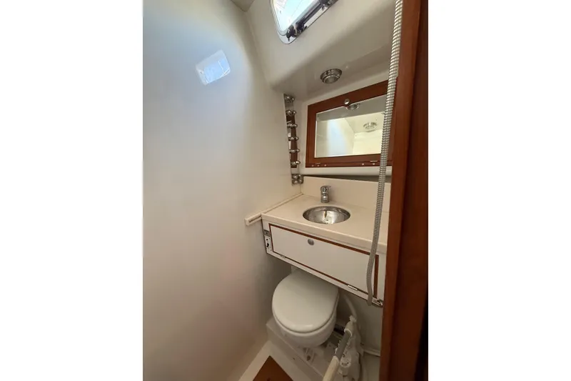Slide: The Image of 2011 Outbound 46 yacht head with sink slid inboard, mirror, and toilet. - 46