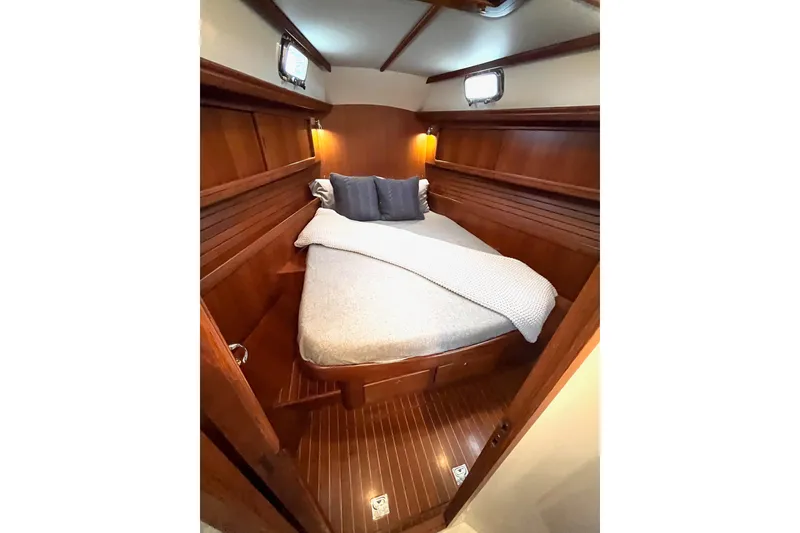 Slide: The Image of Cozy cabin interior of 2011 Outbound 46 yacht with wooden finish and comfortable bedding. - 47