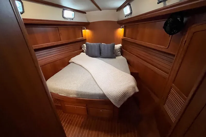 Slide: The Image of Luxurious 2011 Outbound 46 yacht cabin with cozy bed and wooden interior. - 49