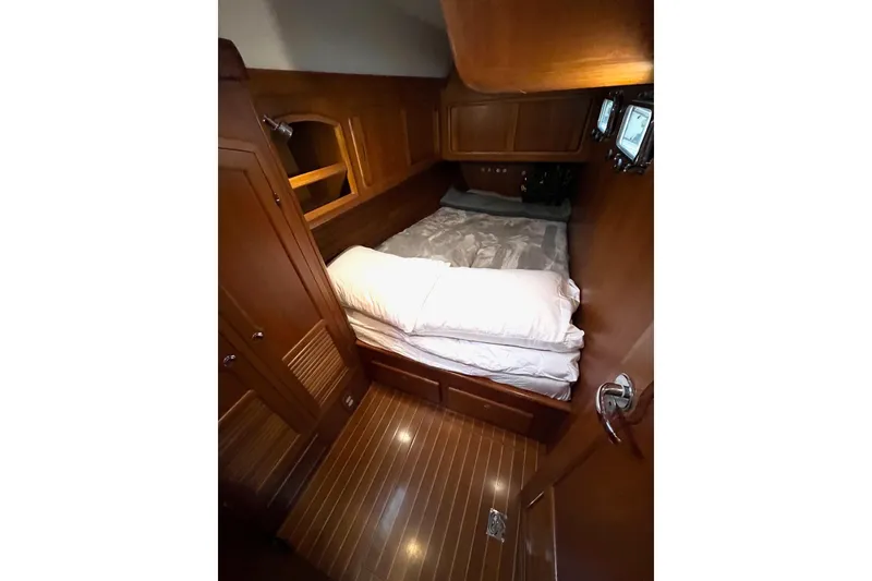 Slide: The Image of Cozy aft cabin interior of 2011 Outbound 46 yacht with wooden finish and comfortable bedding. - 61
