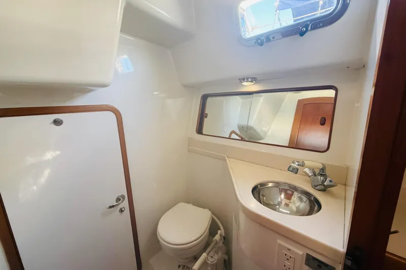 Slide: The Image of 2011 Outbound 46 yacht aft head with sink, shower, toilet, and entrance to the aft storage area - 64