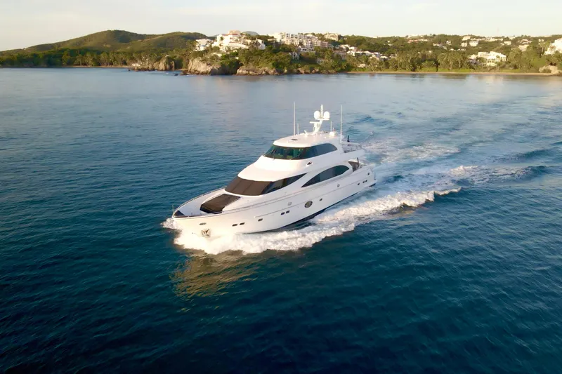 Slide: The Image of Luxurious 2011 Horizon E88 yacht cruising on serene blue waters near a scenic coastline. - 2