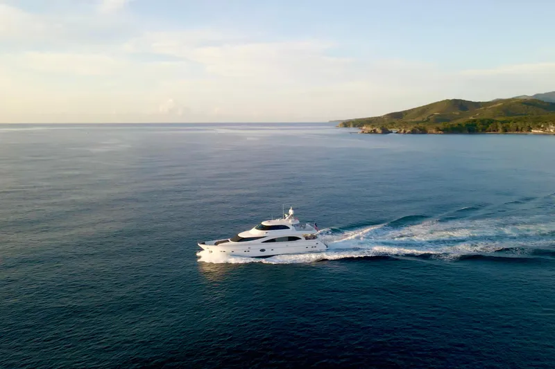 Slide: The Image of Luxurious 2011 Horizon E88 yacht cruising on serene ocean near lush coastline. - 4