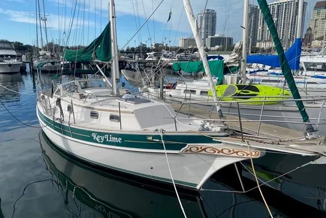 The Image of Sailboat "Key Lime" docked at marina, Gozard 31 model, 1996, with city skyline background. - 0
