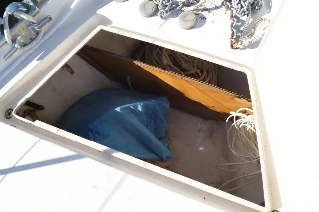 Slide: The Image of Open storage compartment on 1996 Gozard 31 boat with ropes and blue cover. - 10