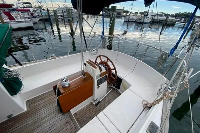 Slide: The Image of 1996 Gozard 31 sailboat cockpit with wooden steering wheel, docked at marina. - 15