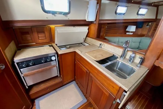 Slide: The Image of 1996 Gozard 31 yacht kitchen with wooden cabinetry, stove, and dual sink. - 24