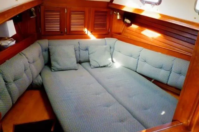 Slide: The Image of Cozy interior of 1996 Gozard 31 sailboat with cushioned seating and wooden accents. - 27