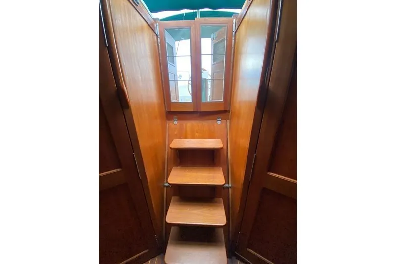 Slide: The Image of Wooden interior stairs on a 1996 Gozard 31 boat, leading to a glass door. - 37