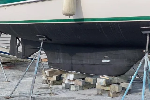 Slide: The Image of 1996 Gozard 31 boat hull on stands, supported by wooden blocks. - 4