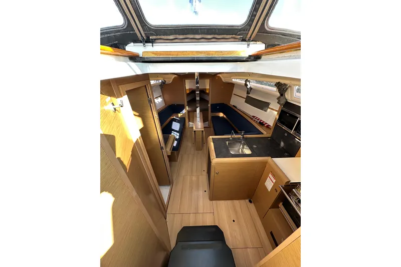 Slide: The Image of Interior of 2021 Jeanneau Sun Odyssey 349 sailboat, featuring modern wood finish and compact kitchen. - 31
