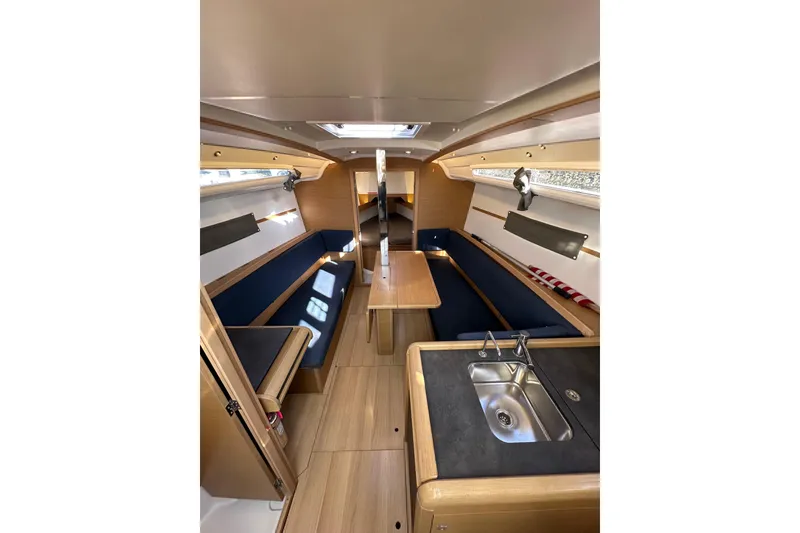 Slide: The Image of Interior of 2021 Jeanneau Sun Odyssey 349 sailboat, featuring modern wood finish and compact kitchen. - 32