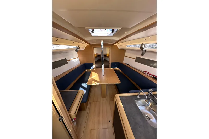 Slide: The Image of Interior of 2021 Jeanneau Sun Odyssey 349 sailboat, featuring a cozy dining area and kitchenette. - 33