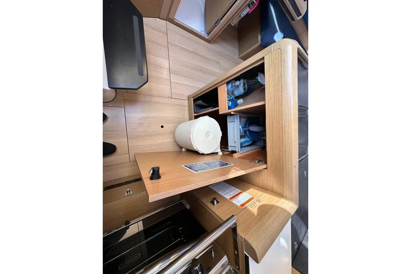 Slide: The Image of Interior of 2021 Jeanneau Sun Odyssey 349 yacht with wooden cabinetry and storage compartments. - 42
