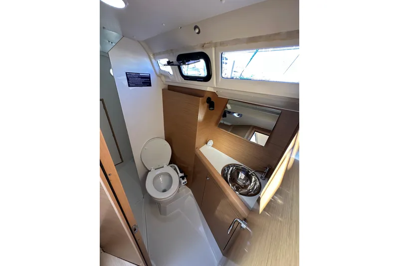Slide: The Image of 2021 Jeanneau Sun Odyssey 349 yacht bathroom with toilet, sink, and mirror. - 57