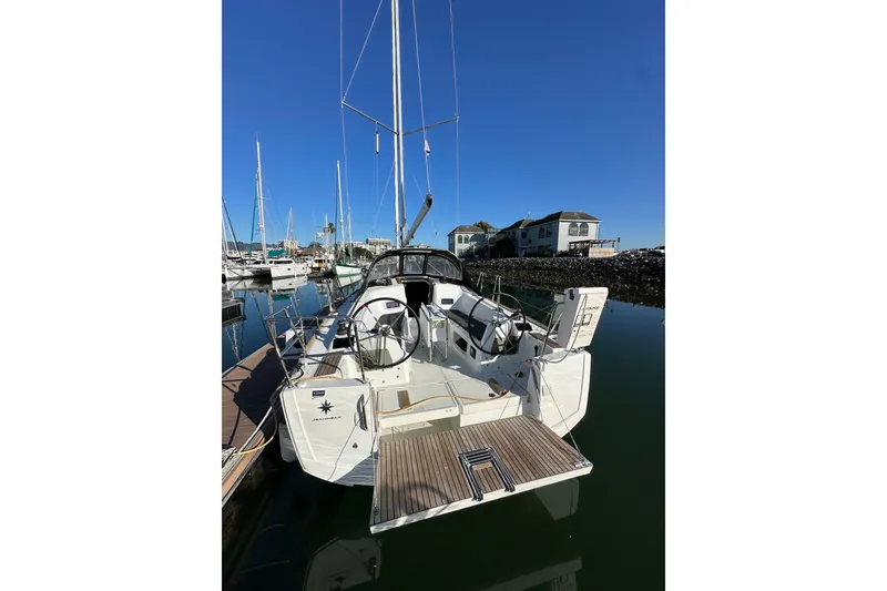 Slide: The Image of 2021 Jeanneau Sun Odyssey 349 sailboat docked in a marina under clear blue skies. - 6