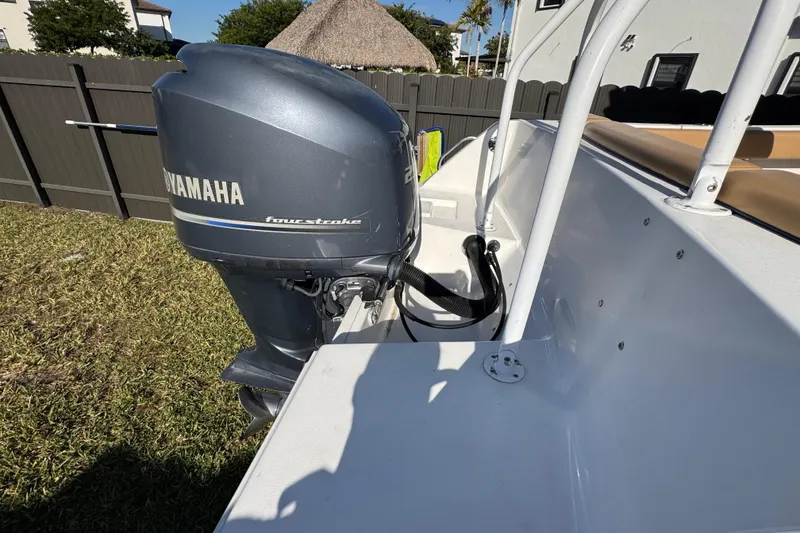Slide: The Image of 2014 Sportsman Heritage 231 Center Console with Yamaha four-stroke engine in a yard setting. - 10