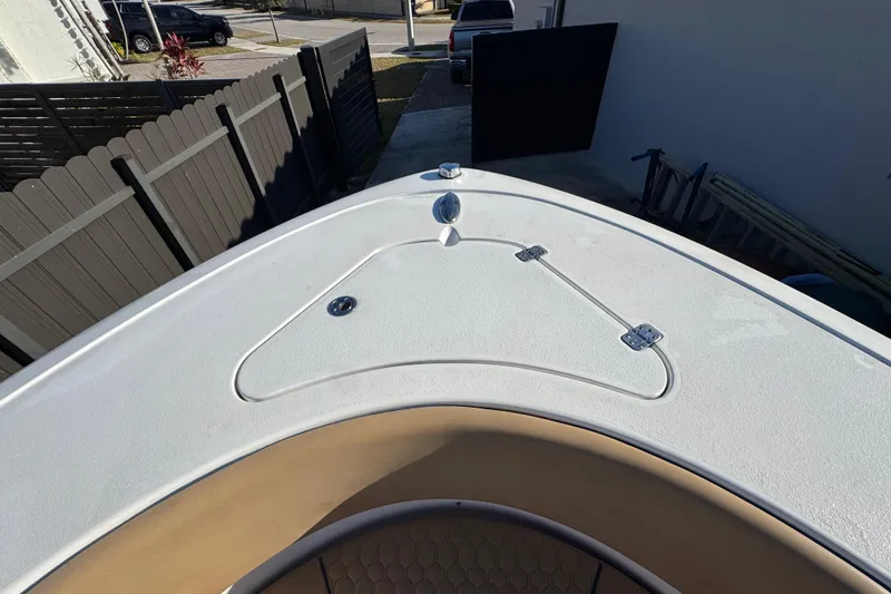 Slide: The Image of 2014 Sportsman Heritage 231 Center Console boat deck, featuring storage hatch and sleek design. - 13