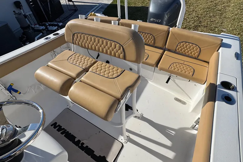Slide: The Image of 2014 Sportsman Heritage 231 Center Console boat interior with tan cushioned seating. - 22