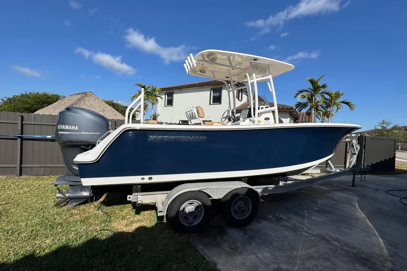 Slide: The Image of 2014 Sportsman Heritage 231 Center Console boat on trailer, parked outdoors under blue sky. - 3