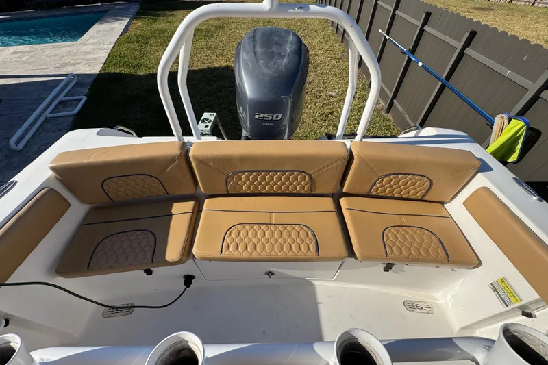 Slide: The Image of 2014 Sportsman Heritage 231 Center Console boat with tan cushioned seating and powerful outboard motor. - 31