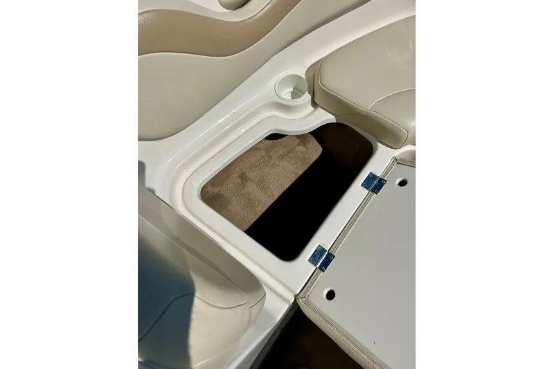 Slide: The Image of 2003 Chaparral 183 SS boat interior storage compartment with beige seating and cup holder. - 14