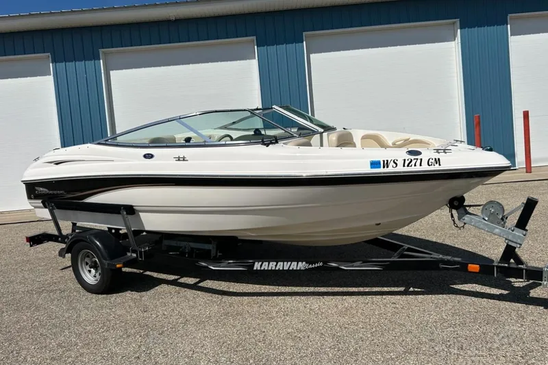 Slide: The Image of 2003 Chaparral 183 SS boat on trailer, parked outside blue building. - 2