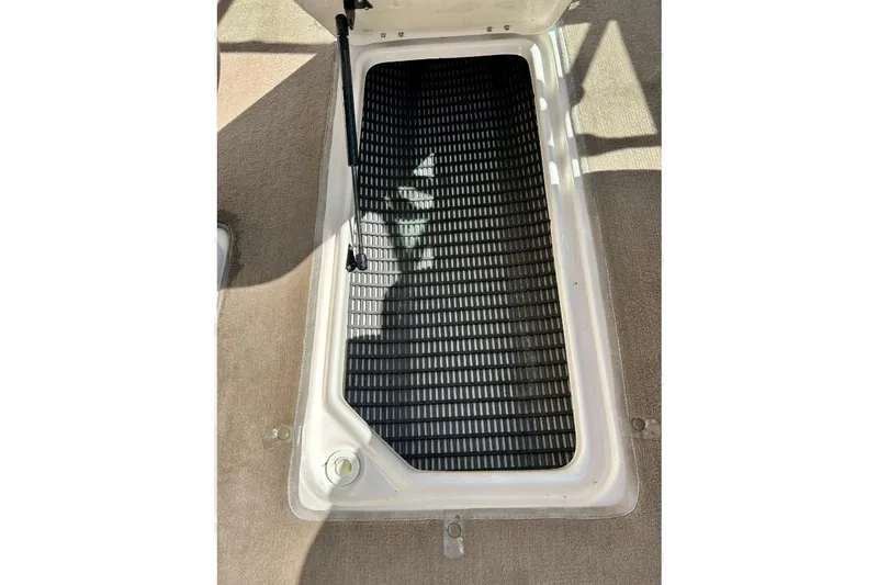 Slide: The Image of Open storage compartment in 2003 Chaparral 183 SS boat, featuring black non-slip mat. - 33