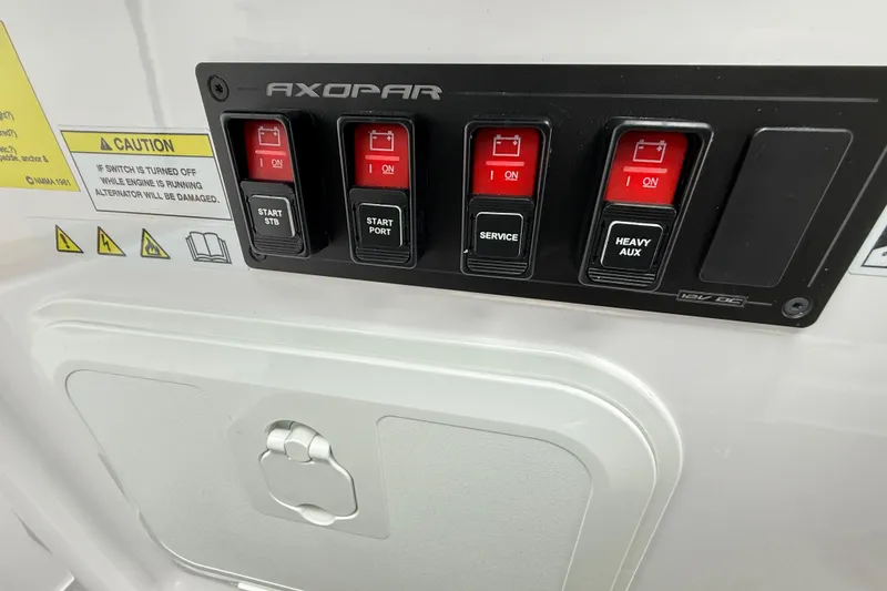 Slide: The Image of Control panel of 2025 Axopar 37 XC Cross Cabin with labeled switches and caution sign. - 29