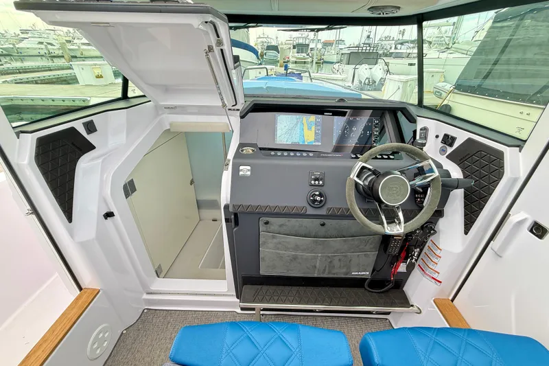 Slide: The Image of 2025 Axopar 37 XC Cross Cabin interior with modern steering and navigation system. - 33